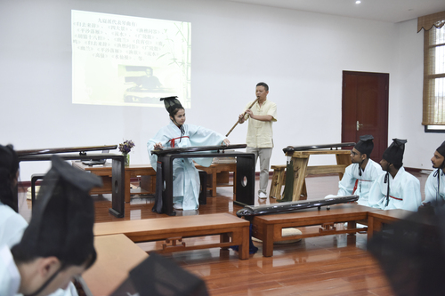 6月21日，九游在线国学院，古乐老师欧阳平彪与来自塔吉克斯坦的留学生sayora（佑娜）在合奏《高山流水》。 李谌涵 摄